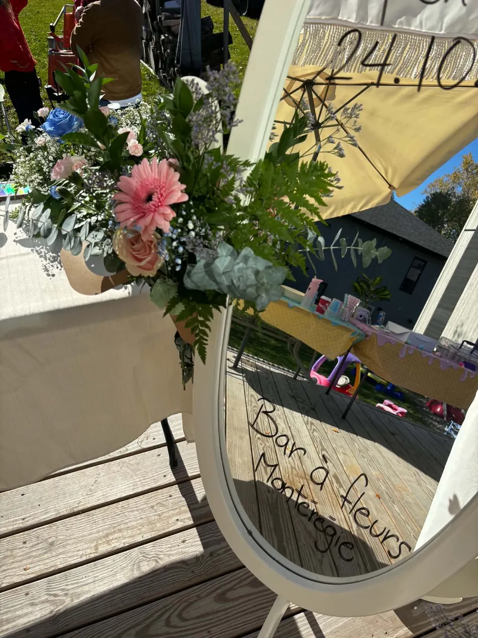 Bouquet dans un cornet kraft devant le miroir où est écrit Bar à fleurs Montérégie
