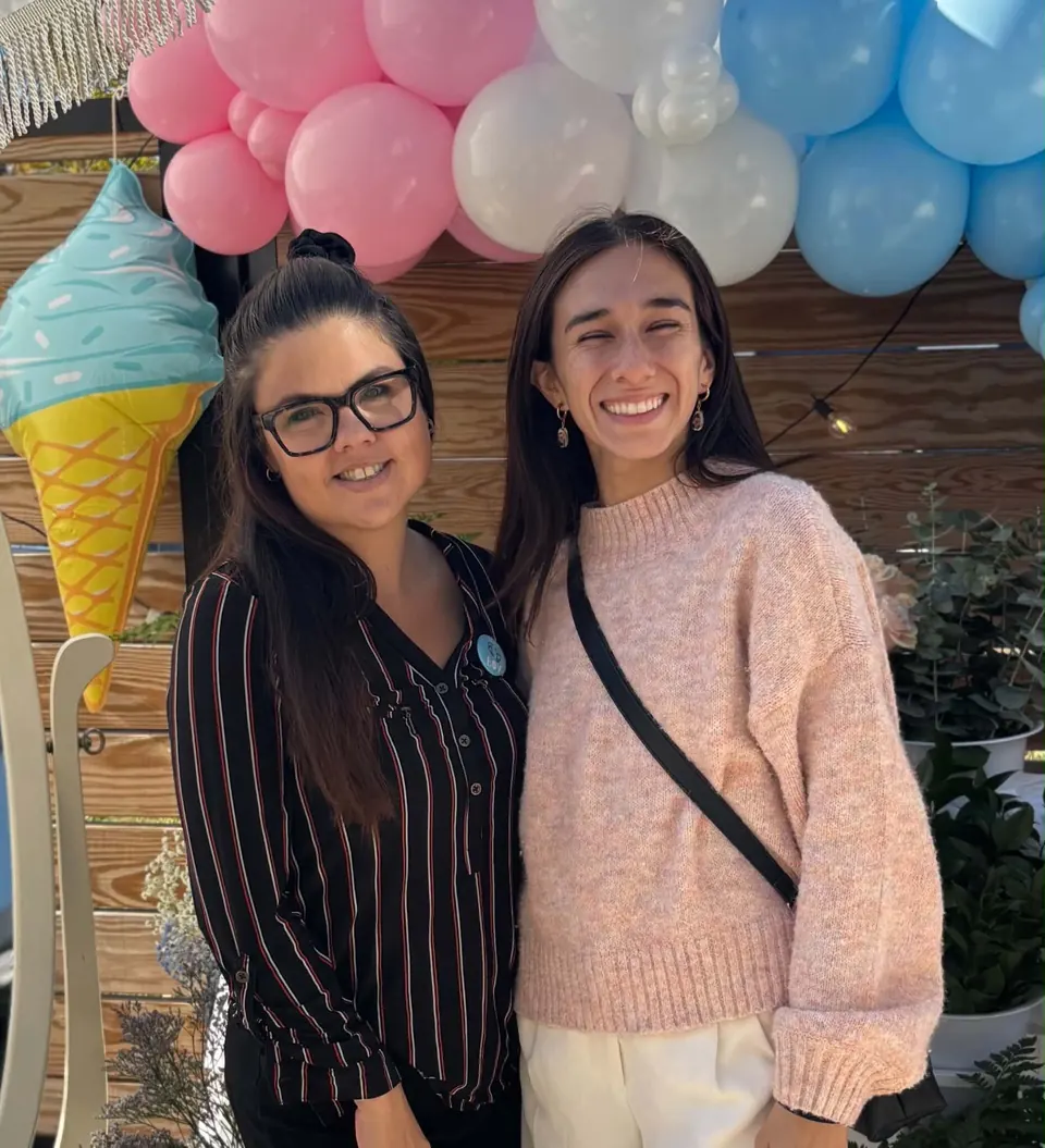 Catherine et Dulcée, propriétaires de Bar à fleurs Montérégie, souriantes devant une arche de ballons rose, blanc et bleu