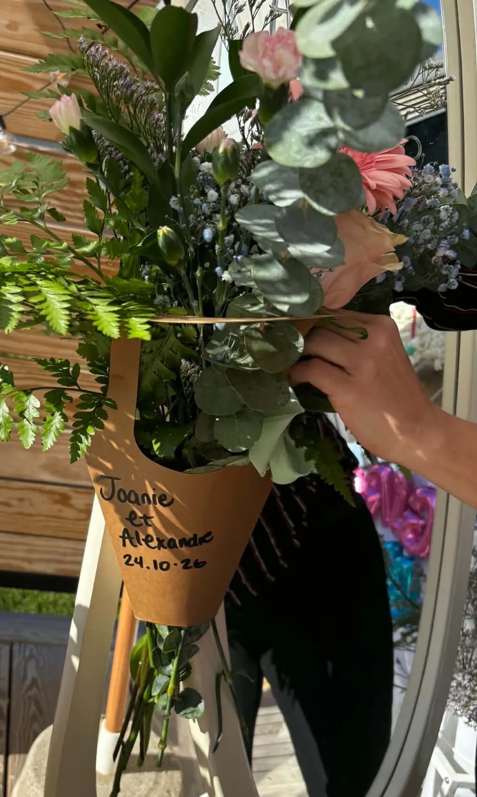Bouquet de fougère, eucalyptus et œillets dans un cornet kraft écrit à la main Joanie et Alexandre 24.10.26